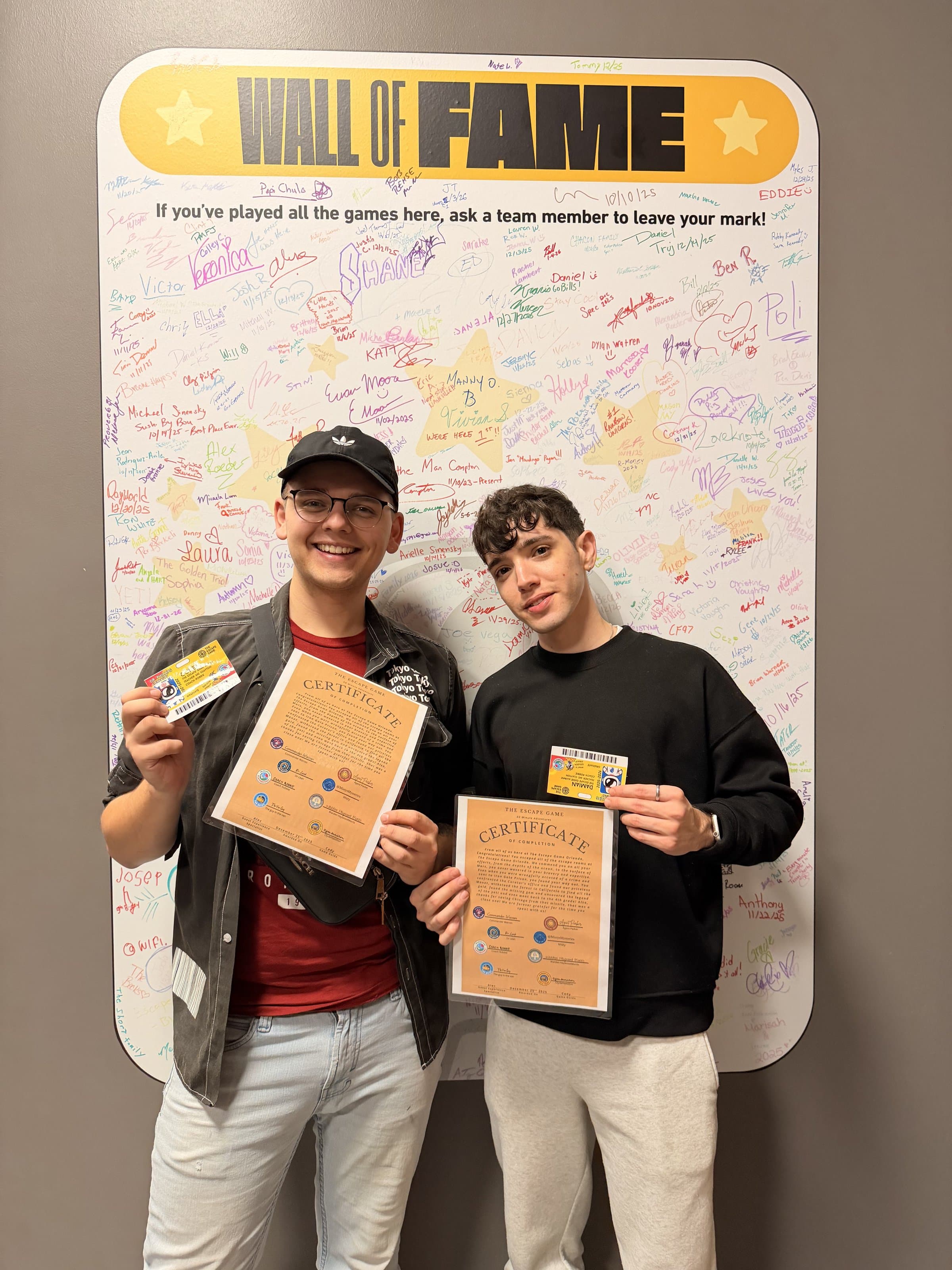 Holding Wall of Fame certificates after completing every single escape room